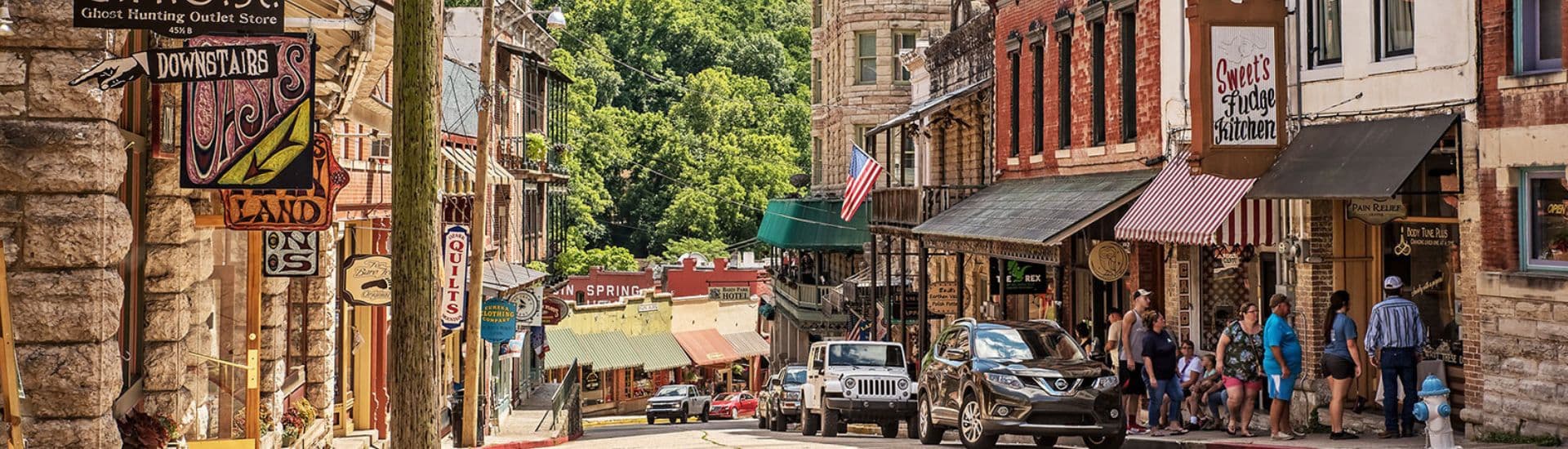 Quaint main street shopping district with brick buildings, colorful awnings and signs and people shopping