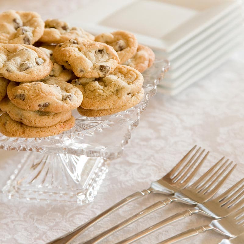 A glass platter filled with chocolate chip cookies.