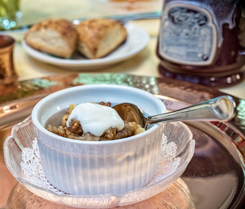 A bowl of oatmeal topped with yogurt and a spoon.