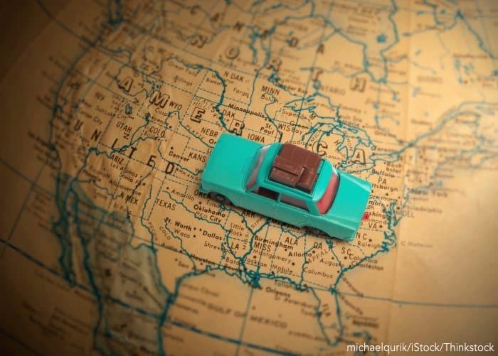 A toy car sits on a vintage map of the United States.
