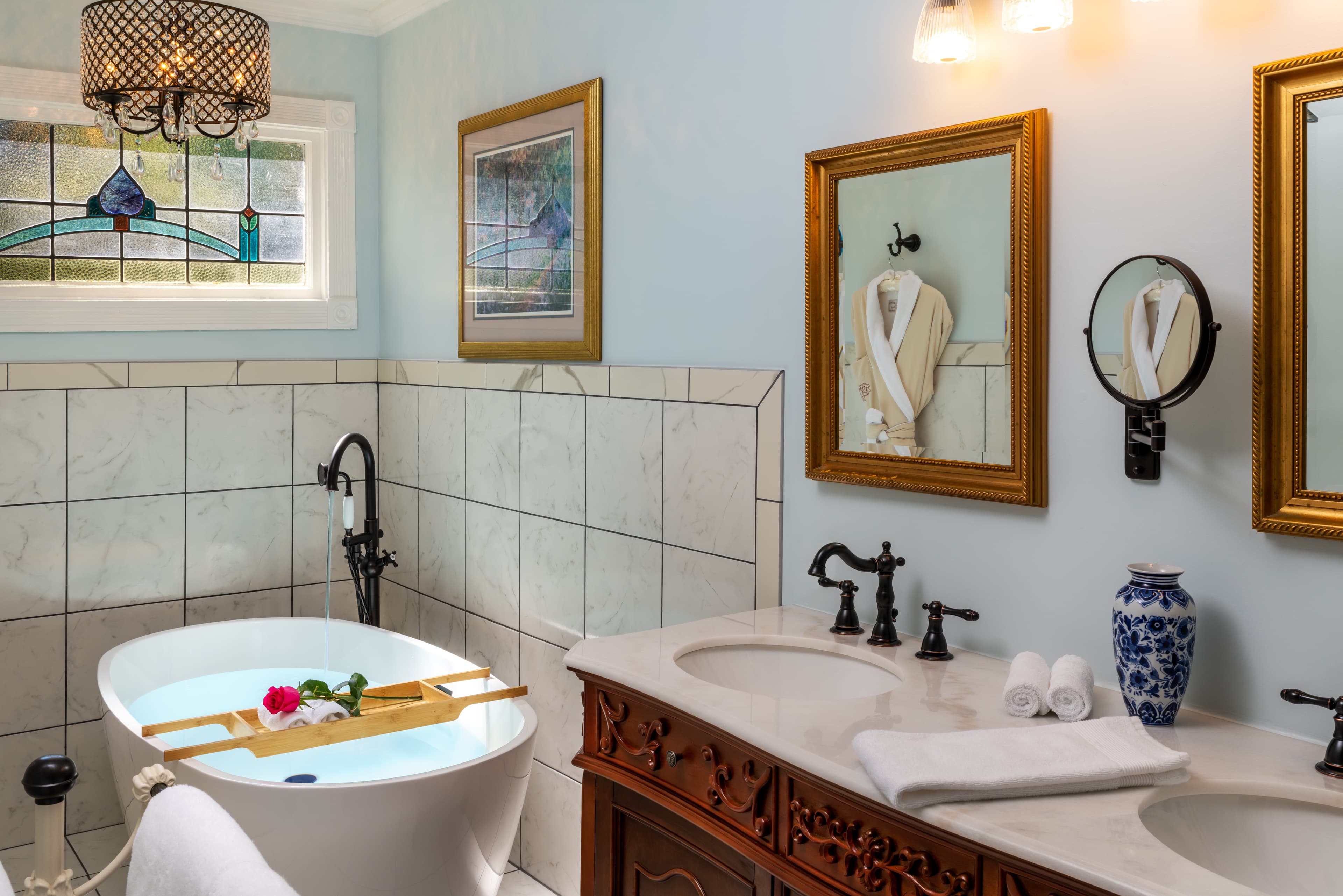 Luxurious bathroom featuring a freestanding tub, double sinks, and elegant decor.