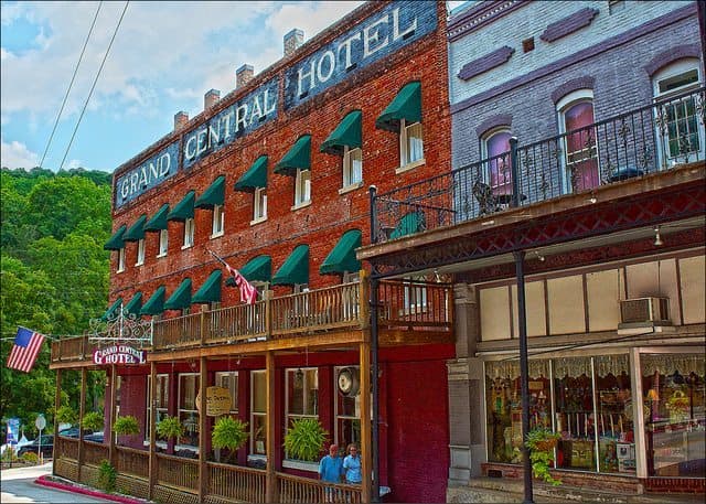 Historic brick facade of the Grand Central Hotel, featuring green awnings and American flags. Historic brick facade of the Grand Central Hotel, featuring green awnings and American flags.