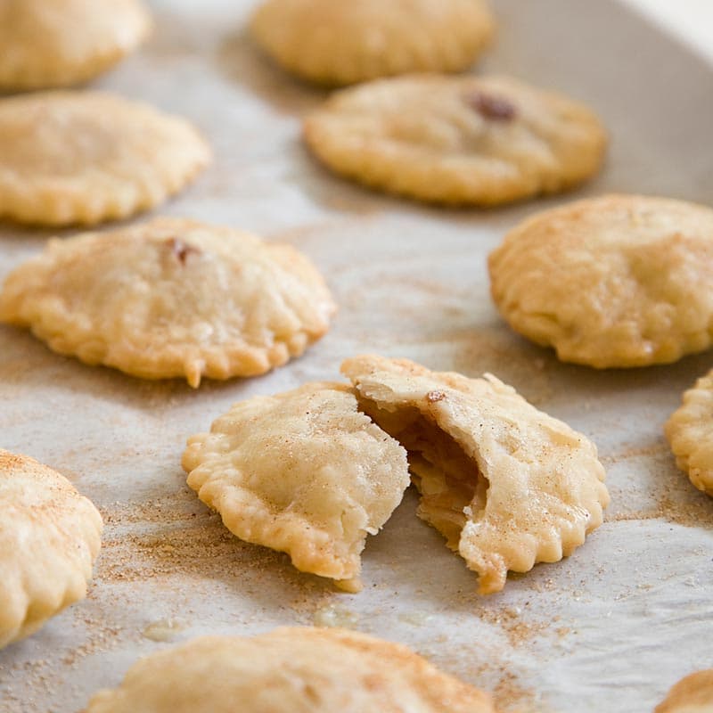 A baking sheet filled with mini apple pies.