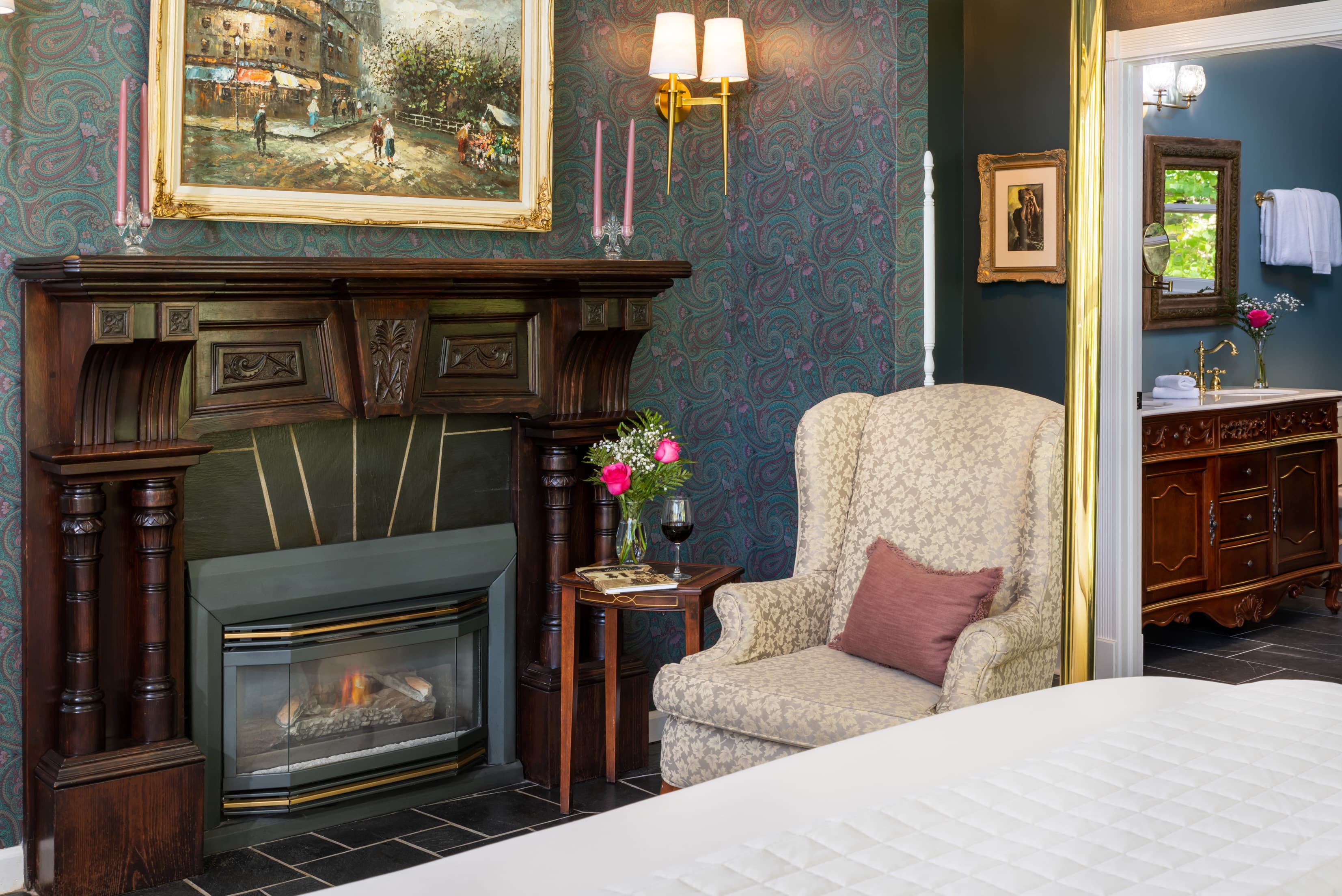 Cozy room featuring a decorative fireplace, armchair, and elegant art on the walls.