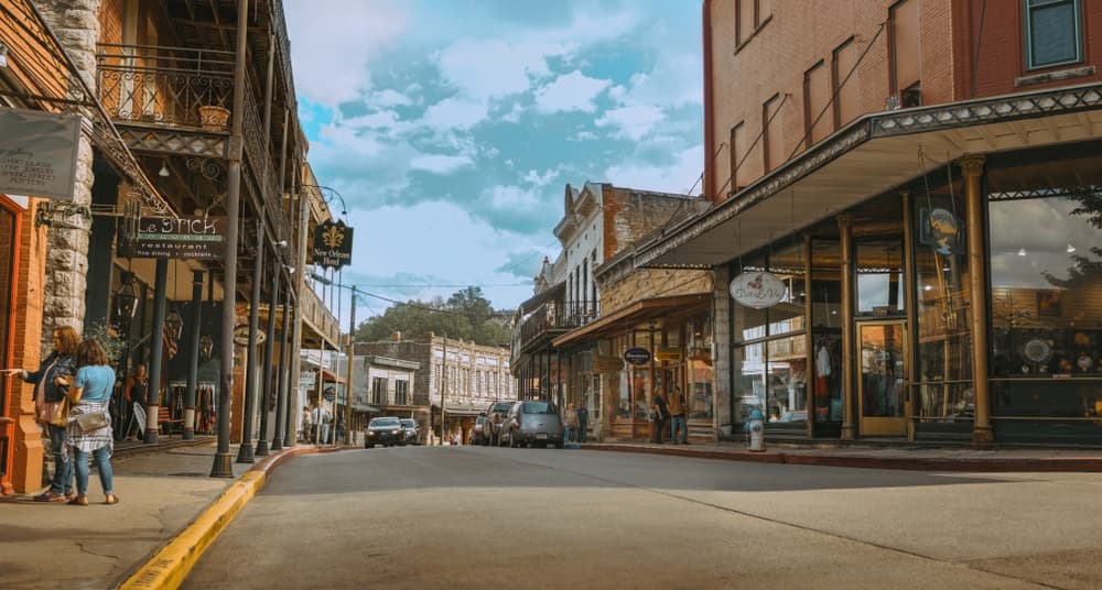 A quiet street view of a historic downtown area with shops and blue skies.