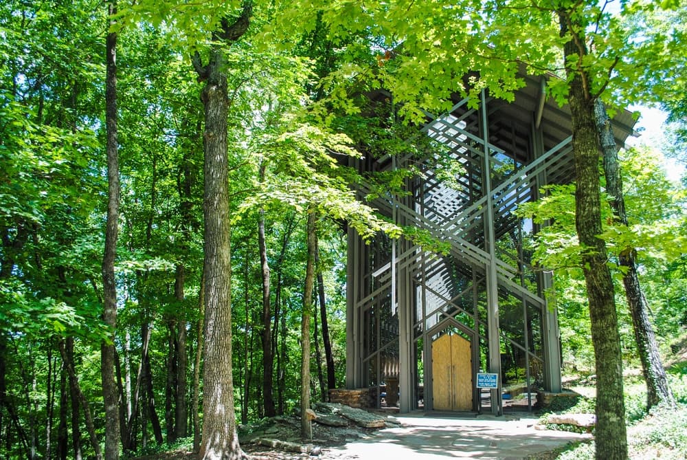 A modern glass and wood structure nestled among lush green trees. A modern glass and wood structure nestled among lush green trees.