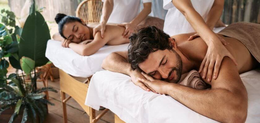Two people receiving massages in a serene spa setting.